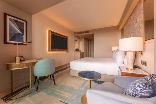 a hotel room with a bed and a couch at Legacy Hotel Cascais, Curio Collection By Hilton in Cascais