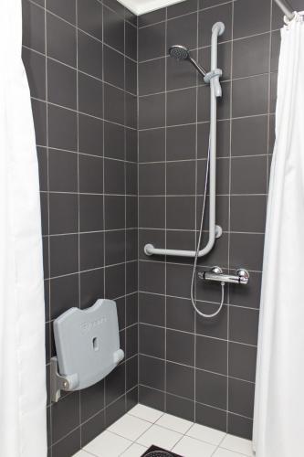 a bathroom with a shower with a toilet in it at Hotell Fritidsparken in Skien
