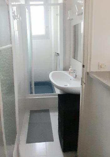 une salle de bain blanche avec un lavabo et une douche dans l'établissement Les Palmiers NiceAirport, Beach200m, 2bedrooms, Wifi Optic, à Nice