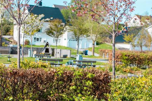 a park with picnic tables and trees and buildings at Quality Hotel Ulstein in Ulsteinvik