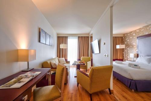 een hotelkamer met een bed en een bureau bij Clarion Paris CDG Airport in Roissy-en-France