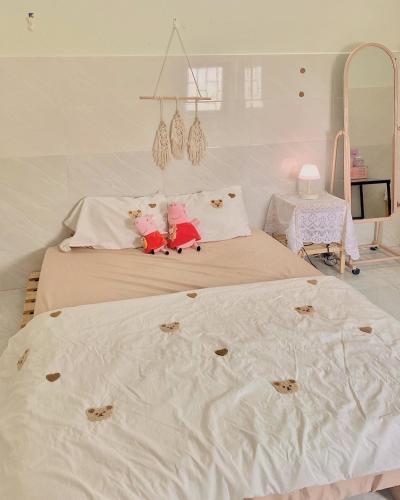 a bedroom with two beds with white sheets and a table at Homestay Tuyết Trinh in Nha Trang