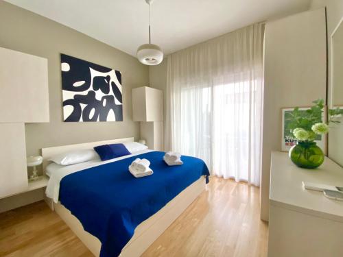 AstraMaris Znjan - Deluxe beach suite with hot tub في سبليت: غرفة نوم بسرير ازرق عليها منشفتين