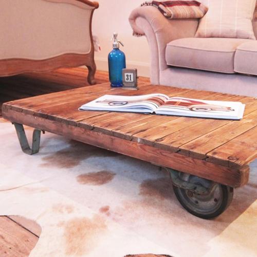 a coffee table in a living room with a book on it at The Lodge at Blue Door Barns in Beddingham