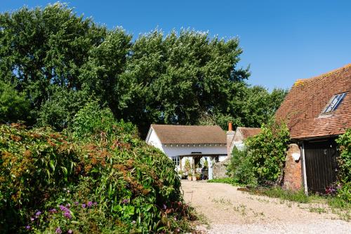a couple of houses with trees and a road at The Lodge at Blue Door Barns in Beddingham