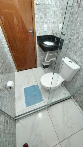 a bathroom with a toilet and a sink at Suítes Privativas em Guriri in Guriri