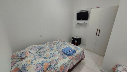 a bedroom with a bed with a blue bag on it at Suítes Privativas em Guriri in Guriri