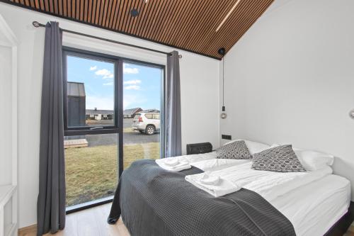 sypialnia z łóżkiem i dużym oknem w obiekcie Arctic Exclusive Ranch w mieście Kirkjubæjarklaustur