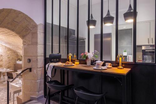 uma cozinha com um bar com paredes em preto e branco em Hôtel Saint Martin Bastille em Paris