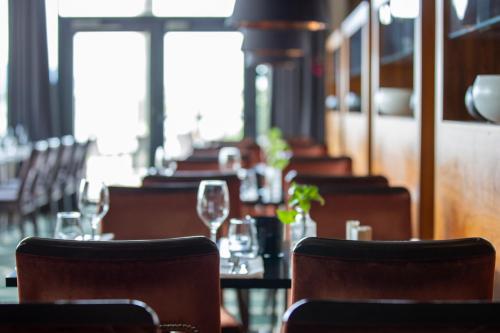 a restaurant with tables and chairs with wine glasses at Quality Hotel Ulstein in Ulsteinvik