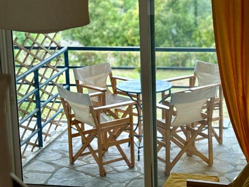 un tavolo e delle sedie su un balcone con una finestra di Sunset Hill Escape a Skála Foúrkas