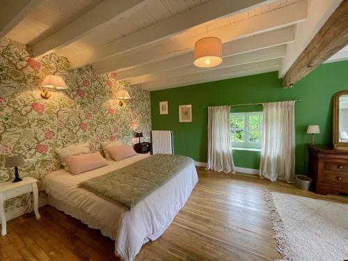 a bedroom with a bed and a green wall at La Grenouillère in Saint-Estèphe
