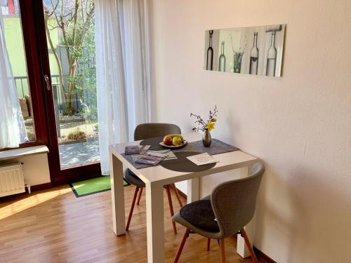 einen weißen Tisch mit zwei Stühlen und eine Schale Obst darauf in der Unterkunft Appartement 51 in Schwäbisch Hall