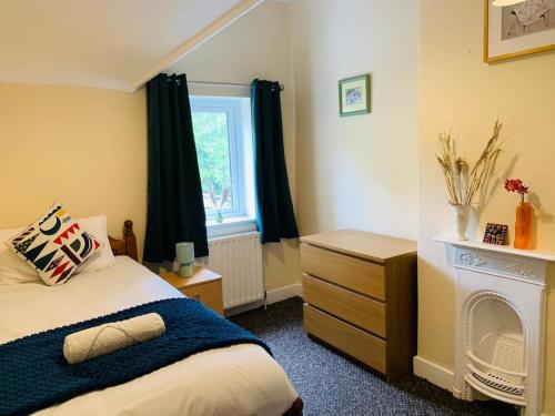 a bedroom with a bed and a dresser and a window at Families and contractors Free off road parking in Huntingdon