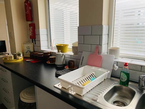 a kitchen counter with a dish drying rack next to a sink at Families and contractors Free off road parking in Huntingdon