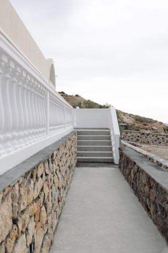 a stairway leading up to a building with a stone wall at Kaminia Holiday Homes in Éxo Goniá