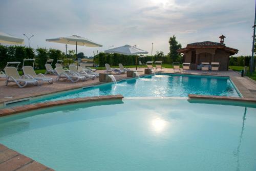 einen großen Pool mit Stühlen und einem Pavillon in der Unterkunft Hotel La Tavola Rotonda in Cortemaggiore