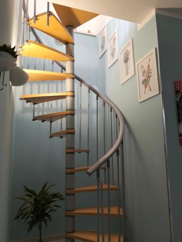 a wooden spiral staircase in a home with white walls at Casa vacanze Vista Castello in Oria
