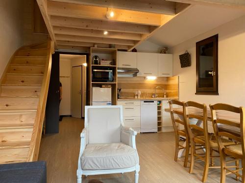 une cuisine avec une chaise blanche et une cuisine avec un escalier dans l'établissement Laveissiere, à Laveissière