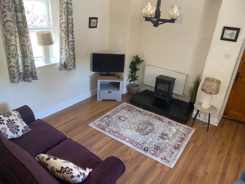a living room with a couch and a flat screen tv at Tully Cottage Donegal Town in Donegal