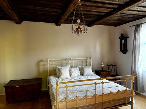 a bedroom with a bed with a chandelier at Lauku Mickas Country House in Zirņi