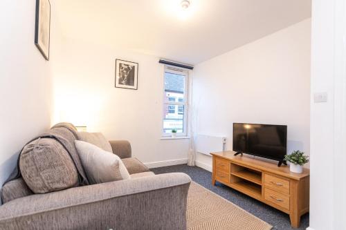 un soggiorno con divano e TV a schermo piatto di June Disc - Long Stay - Contractors a Bristol