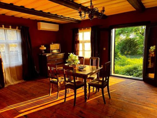 a dining room with a table and chairs and a window at Lauku Mickas Country House in Zirņi