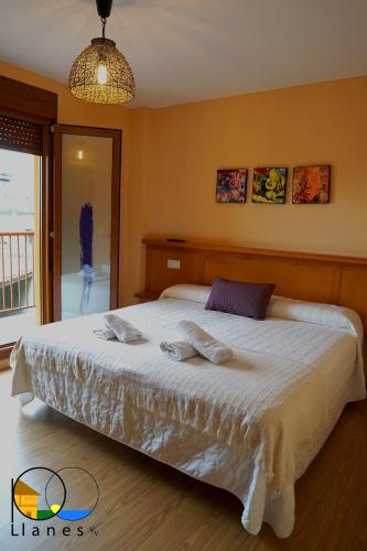 a bedroom with a bed with two towels on it at Adosado en LLanes in Llanes