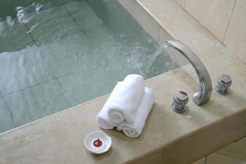 een wastafel met een handdoek en een douche bij 蝴蝶結溜滑梯親子民宿 in Yuanshan