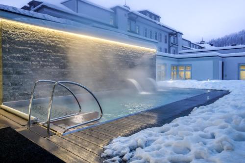 una bañera de hidromasaje en una casa cubierta de nieve en Grand Hotel des Bains Kempinski, en St. Moritz