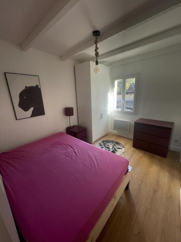 une chambre avec un grand lit avec une couverture violette dans l'établissement maison Bastide 5 mn de la plage, à Six-Fours-les-Plages