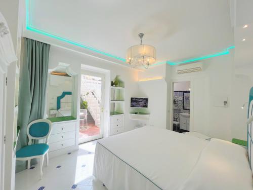 a white bedroom with a large bed and a mirror at Villa Fiorentino in Positano