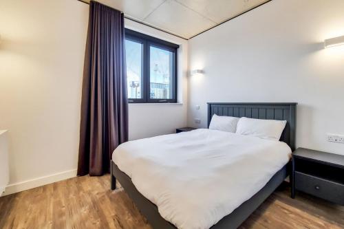 a bedroom with a large bed and a window at Repton Gardens at Wembley Park in London