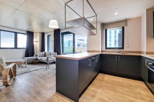 a kitchen with a large island in a room with windows at Repton Gardens at Wembley Park in London