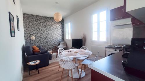 une cuisine et un salon avec une table et des chaises dans l'établissement Le Grain de Sable, à Royan