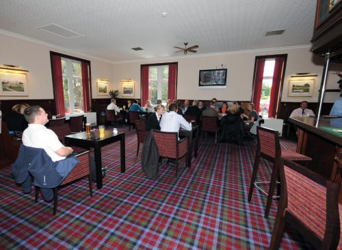 um grupo de pessoas sentadas em mesas em um restaurante em Pinehurst Lodge Hotel - Aberdeen em Dyce