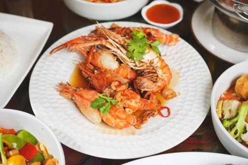 a white plate of food with shrimp and other foods at MeStyle Place Hotel in Bangkok
