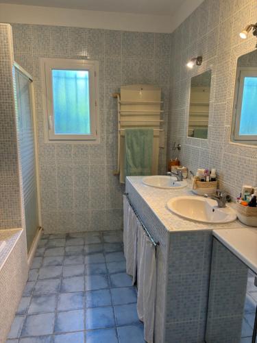 a bathroom with two sinks and two mirrors at Villa Arles Trinquetaille in Arles