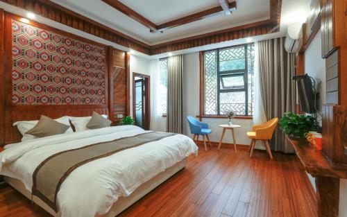 um quarto com uma cama, uma mesa e cadeiras em Easy House Gaoyun Branch em Zhangjiajie