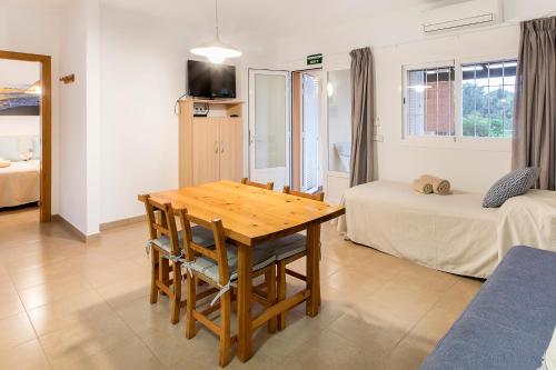 a room with a wooden table and a bed and a table and chairs at Ca Sa Vilda in Es Pujols