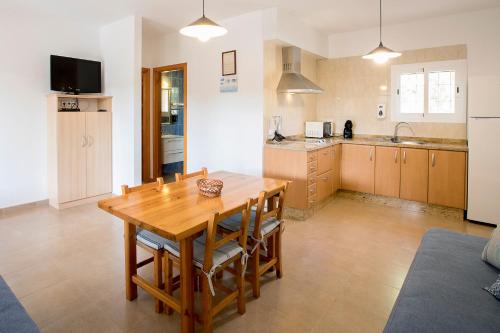 a kitchen with a wooden table and chairs in a room at Ca Sa Vilda in Es Pujols