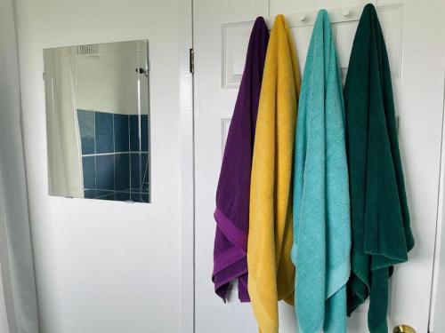 a bunch of towels hanging on a rack in a bathroom at Warwick House, 5 bedrooms, 9 beds, parking, garden in Coventry
