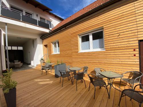a wooden deck with tables and chairs on a building at Apartments Freitag - H1 in Winden am See