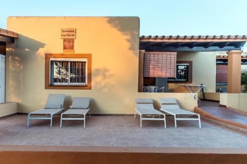 a group of chairs sitting next to a building at Ca Sa Vilda in Es Pujols