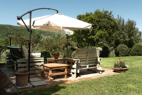 a patio with two chairs and an umbrella at La Vittoria 10 – La Soglia della Val d’Orcia in Chianciano Terme