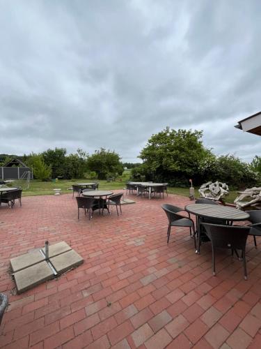 a group of tables and chairs on a brick patio at Bredebro Kro in Bredebro