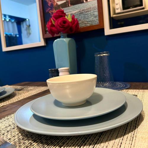 a bowl on a plate on a table with a vase at Casas Reales Staycation & Rentals in Biñan