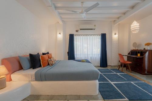 a bedroom with a bed and a desk in it at LohonoStays Villa Santorini in Alibag