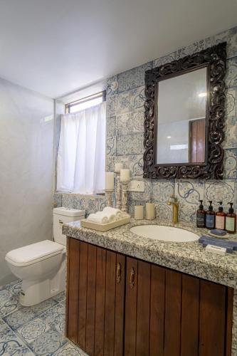 a bathroom with a toilet and a sink and a mirror at LohonoStays Villa Santorini in Alibag