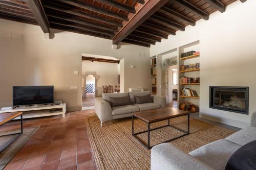 Deco - Casa Castell de Peratallada في بيرتايادا: غرفة معيشة مع أريكة وتلفزيون